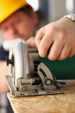 Elektrikli testere kullanan erkek işçi, inşaat alanındaki iyileştirme, diy ilham