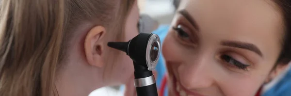 Ent mujer examinando oreja de niña con otoscopio en clínica — Foto de Stock
