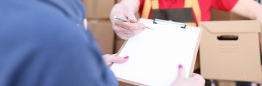 Kurye paketi tutar, kadın belgeyi imzalar