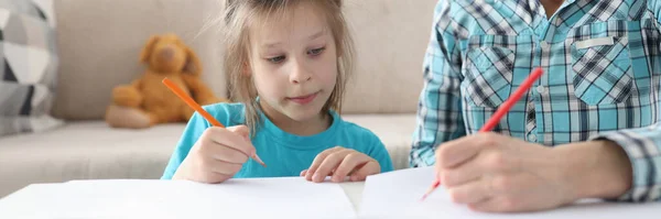 Mamma och dotter ritar vid bordet hemma. — Stockfoto