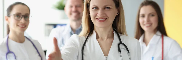 Amigável médico feminino estende a mão — Fotografia de Stock