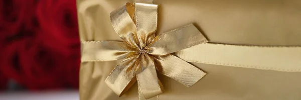 Pudełko na prezenty w złotym opakowaniu ze wstążką, zbliżenie Obrazek Stockowy