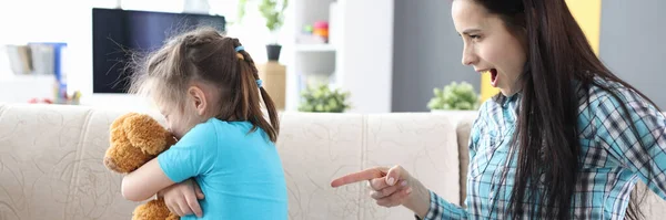 Mutter zeigt Finger auf Tochter, Mädchen mit Spielzeug — Stockfoto