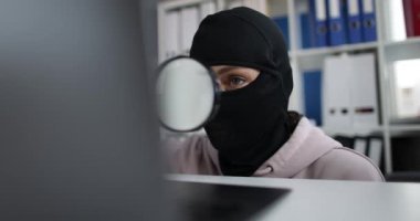 Çalışanların elinde büyüteç var ve bilgisayardan bilgi çalıyor.