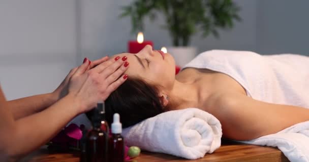 Therapist massaging head of woman in spa center — Stock Video