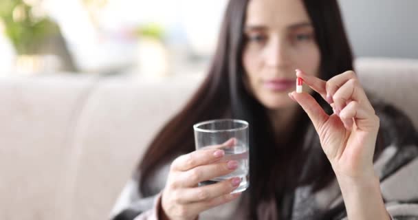 Sjuk kvinna som håller piller och glas vatten närbild — Stockvideo