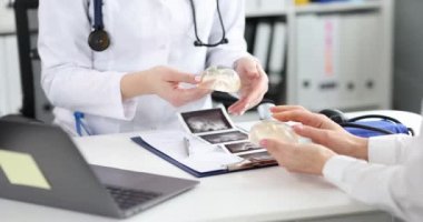 Estetik cerrah klinikteki kadına silikon göğüs implantı gösteriyor.