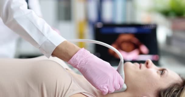 Doctora joven examina paciente cuello con máquina de ultrasonido durante examen médico en hospital moderno — Vídeos de Stock