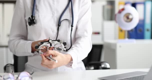 Ophthalmologist holds glasses for selection of lenses in frame closeup — Stock Video