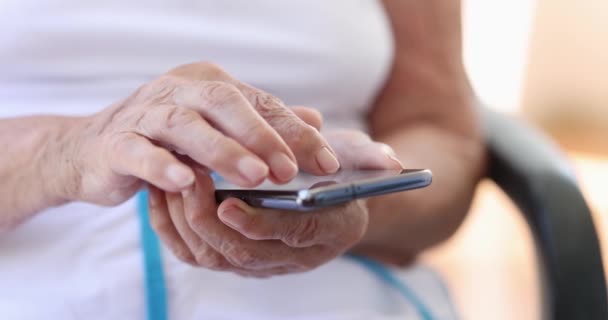 Пожилая женщина печатает сообщение на мобильном телефоне крупным планом 4k фильм замедленной съемки — стоковое видео