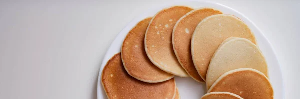 Viele leckere appetitliche Pfannkuchen liegen auf weißem Teller in Kreis-Ansicht — Stockfoto