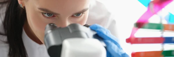 Γυναίκα επιστήμονας κοιτάζοντας μέσα από ένα μικροσκόπιο, μελετώντας το DNA — Φωτογραφία Αρχείου