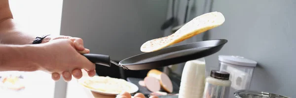 Un hombre fríe tacos en una sartén en casa en la cocina —  Fotos de Stock
