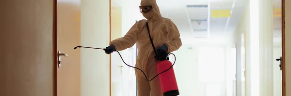 Un homme en costume de protection éclabousse la porte — Photo