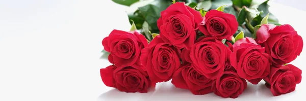 A large bouquet of red roses lies on the table