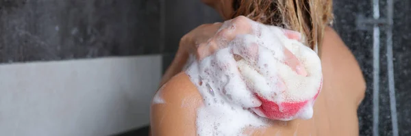 A nő lemossa a testét szivaccsal és tusfürdővel — Stock Fotó