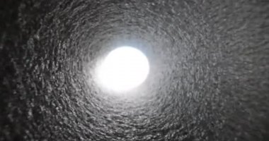 Tünel borusunun sonundaki parlak beyaz ışık. Boş beton tünelin parlak ucu