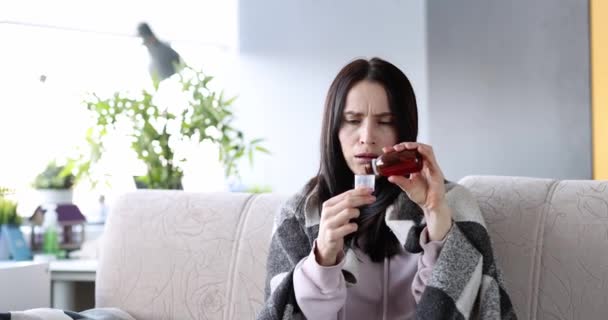 咳をする病気の女性は治療のためにシロップを注ぐ 季節性風邪と治療の概念 — ストック動画