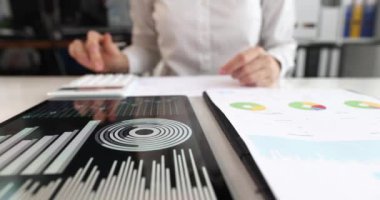 Ofis masasında mali analizcilerle çalışan bir iş adamı. Tablet konsepti üzerine iş grafikleri ile veri hesaplanıyor