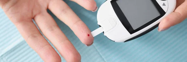 女性手牵着带糖蜜计的特写镜头 医用便携式装置 用于测定血液中葡萄糖的近似浓度 使用葡萄糖计的糖尿病患者 — 图库照片