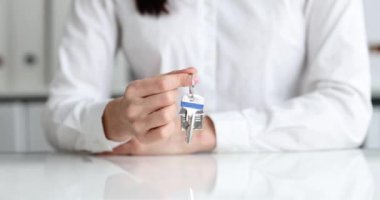 Emlakçı evin anahtarlığını evin anahtarlığında tutuyor. Emlak satışları ve kiralık daireler.
