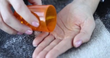 Kadın sarı kapsülleri omega-3 ile dolduruyor. Kız balık yağı konseptini alıyor.