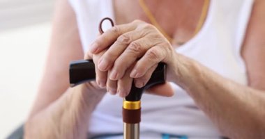 Yalnız, olgun bir kadın baston tutuyor. Üzgün ve bunalımda olan yaşlı büyükannem emekli oldu ve sağlık sorunları yaşıyor.