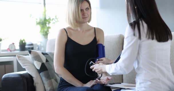 Krankenschwester Überprüft Den Blutdruck Der Frau Hause Arztheimkonzept Abrufen — Stockvideo