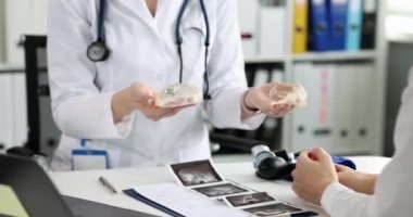 Estetik cerrah, göğüs büyütme konusunda hastalara danışmanlık yapıyor. Göğüs silikonu implantı konsepti