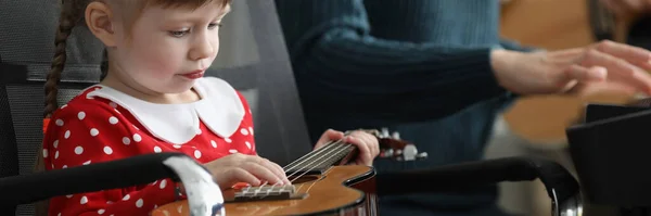 无聊女孩的画像拿着吉他 玩弄乐器 老师弹钢琴时 孩子拉绳 学前教育发展概念 — 图库照片