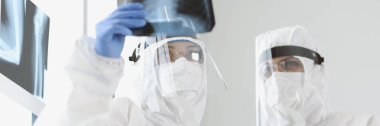 Uzman doktorların portresi klinikteki hastanın akciğerlerinin röntgenini inceler. Sağlık çalışanları tıbbi geçmişi analiz ettiler. Sağlık, kontrol konsepti