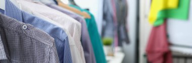 Farklı renkte erkek gömlekleriyle korkuluklara yakın çekim. Modern stilist ilham verici bir ofis. Couturier Showroom, atölye, moda konsepti