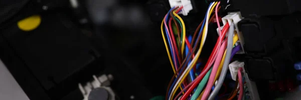 Close-up of large wide cable with multicolored wires and connectors in car. Electric connector plug of car engine. Maintenance for automobile fix concept