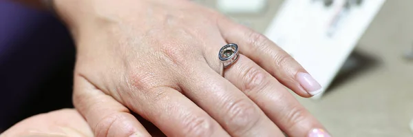Woman choosing silver ring in jewelry store closeup. Buying jewelry concept