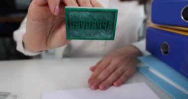 Kadın eli, yakın plan bir kağıda pul yapıştırır. Belge onayı, yavaş çekim. Pozitif karar