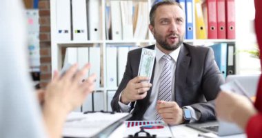 Ofisteki işadamı dolar sallıyor, yakın plan, yavaş çekim. Kazanç dağılımı takımda