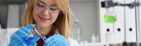 実験室の女性は 試験管に青い液体を注ぎ クローズアップします 化学業界での研究 — ストック写真