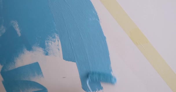 男はローラーで青い壁を描く クローズアップ 装飾石膏 カラーマッチング — ストック動画