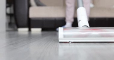 Evde bir kadın plaminatı elektrikli süpürgeyle temizliyor, yakın plan. Ev aletleri, sığ odak