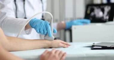 Kadın bir doktor, elinin eklemlerinin ultrasonunu çeker. Yakın çekim, yavaş çekim. El damarlarının klinik incelemesi
