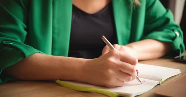 Studentin Grüner Jacke Macht Sich Großaufnahme Notizen Einem Notizbuch Hausaufgabenbetreuung — Stockvideo