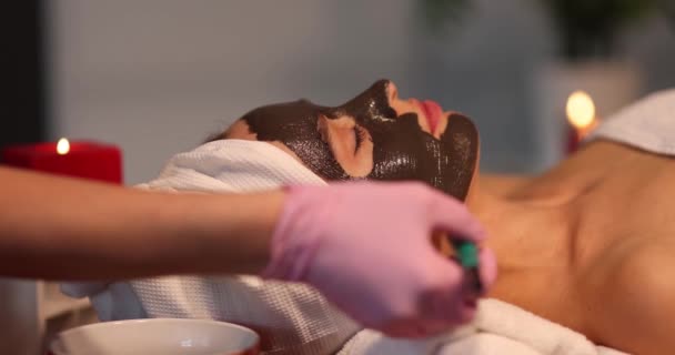 Kvinna Med Lera Mask Ligger Spa Och Gör Föryngring Förfarande — Stockvideo