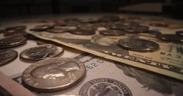 多くの米ドル紙幣と闇の背景にコインが落ちています ハイパーインフレと貨幣印刷の概念 — ストック動画