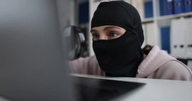 İnternet hırsızlığı ve kar maskeli insanlar dizüstü bilgisayarın arkasında büyüteç var. İnternet fikri mülkiyet hırsızlığı kavramı