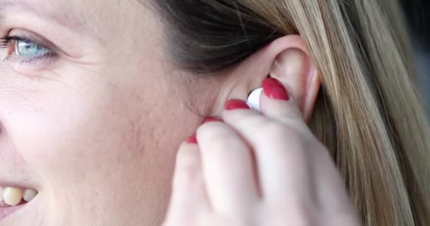 Γυναίκα Εισάγει Λευκό Ασύρματο Ακουστικό Στο Αυτί Ακούγοντας Μουσική Μιλώντας — Αρχείο Βίντεο