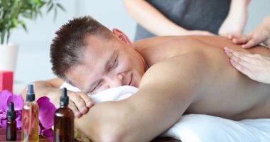 Genç mutlu beyaz adam sırt masajı sırasında dinleniyor. Masöz hizmetleri konsepti