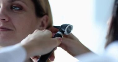 Otorhinolaryngolog otoskopla hasta kulağını inceliyor ve yetişkinlerde işitmeyi kontrol ediyor. Teşhis ve tedavi konsepti otitis inflamasyon kulak konsepti