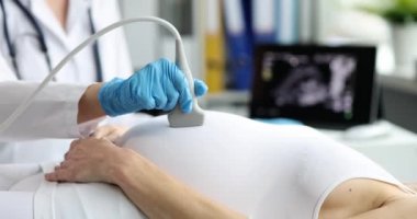 Ultrason cihazı, hamile bir kadının karnını inceleyen profesyonel bir doktorun elinde. Kadın, fetüs bebek konsepti ultrasonu yapıyor.
