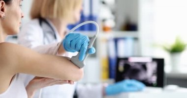 Doktor, hastanın dirsek eklemini ultrasonla muayene ediyor. Dirsek eklemindeki ağrı teşhis ve tedavi konseptine neden olur.