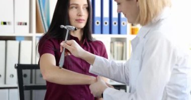 Doktor hasta elinde çekiçle sinir reflekslerini kontrol ediyor. Nörolojik inceleme tekniği